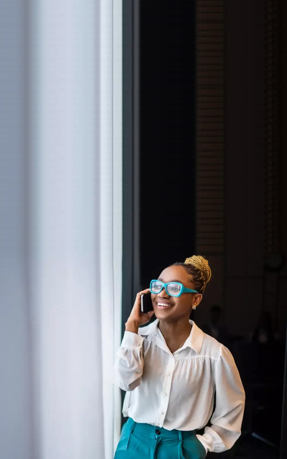 Woman talking on her mobile next to a window